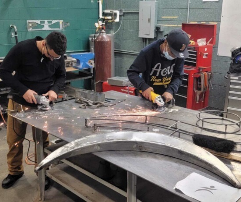Two Madison students build metal sculpture.