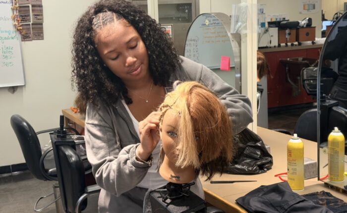 A freshmen styling her mannequin in the cosmetology exploratory program at Madison Park.