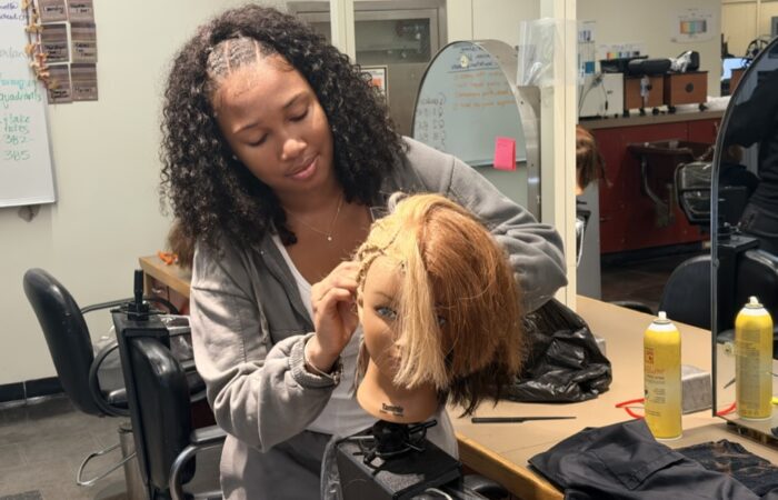 A freshmen styling her mannequin in the cosmetology exploratory program at Madison Park.