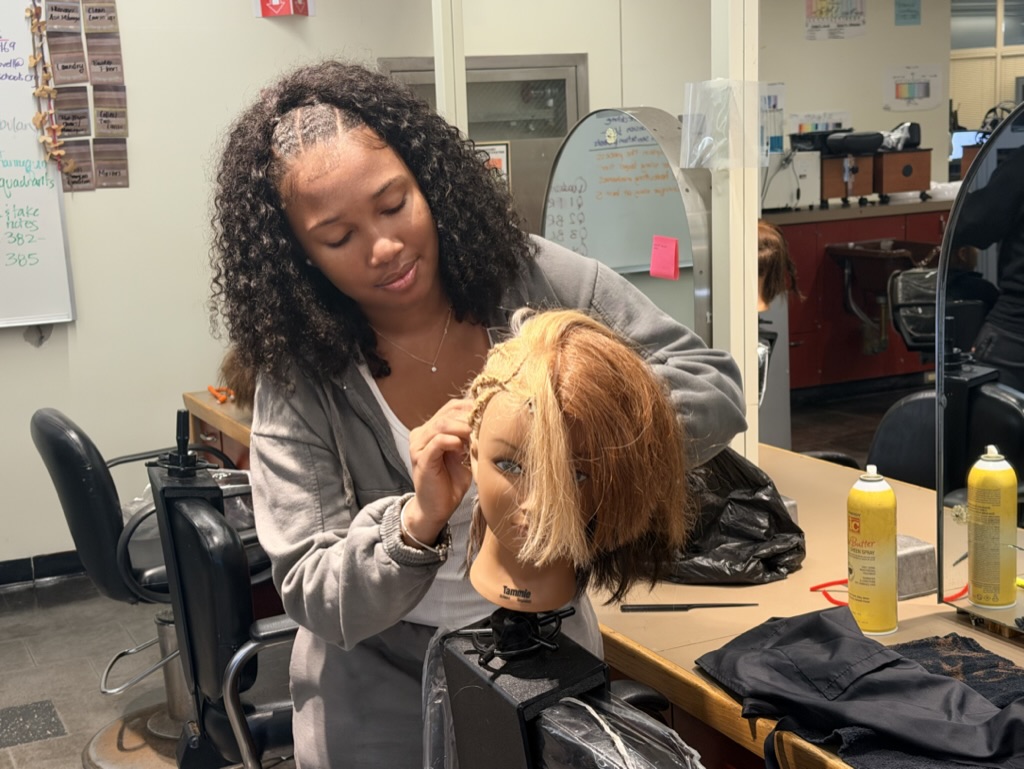 A freshmen styling her mannequin in the cosmetology exploratory program at Madison Park.